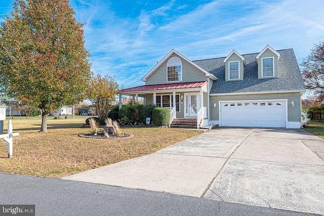 view of front of home featuring covered porch, a garage, and a front yard