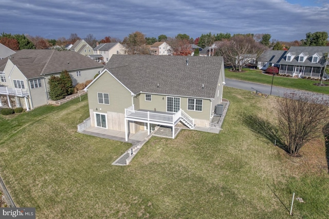 back of house featuring a lawn, a patio area, and a deck