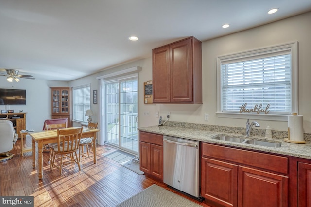 kitchen with hardwood / wood-style floors, dishwasher, sink, ceiling fan, and light stone countertops