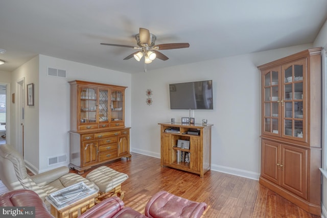 living room featuring light hardwood / wood-style flooring and ceiling fan