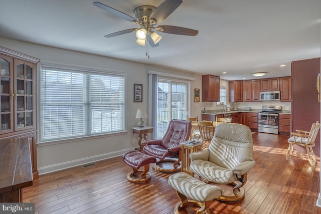 living room featuring ceiling fan and light hardwood / wood-style floors