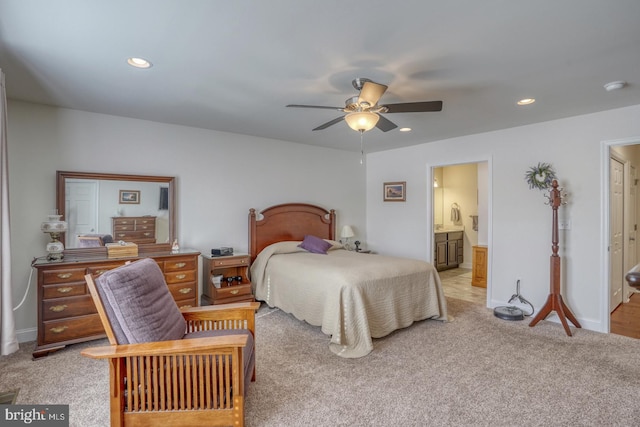 bedroom featuring light carpet, connected bathroom, and ceiling fan