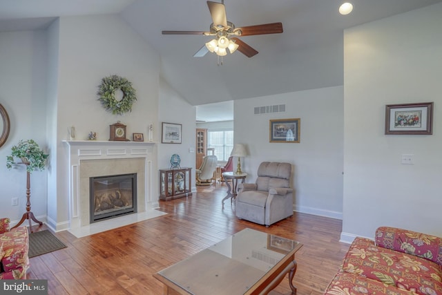 living room with light hardwood / wood-style floors, high vaulted ceiling, and ceiling fan