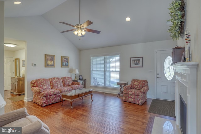 living room featuring hardwood / wood-style flooring, high vaulted ceiling, and ceiling fan