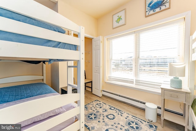 bedroom with light hardwood / wood-style flooring and a baseboard radiator