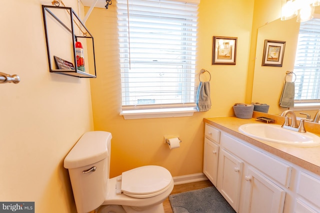 bathroom with vanity, a healthy amount of sunlight, and toilet