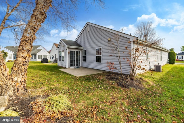 rear view of property featuring a yard, a patio area, and central air condition unit