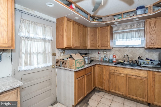 kitchen featuring decorative backsplash, a healthy amount of sunlight, light tile patterned floors, and sink