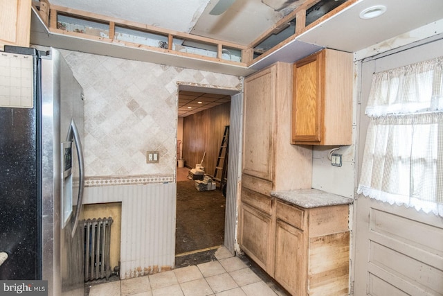 kitchen with stainless steel fridge, radiator heating unit, and light tile patterned floors