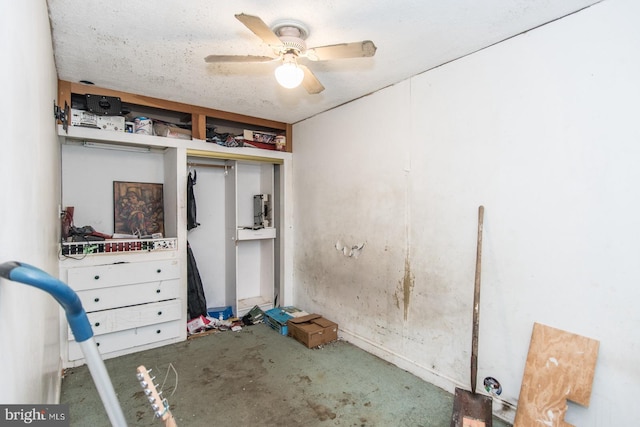 unfurnished bedroom with ceiling fan, concrete flooring, a textured ceiling, and a closet