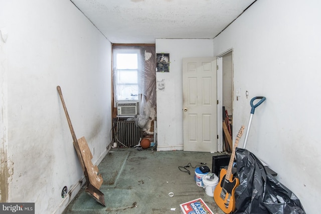 interior space with radiator heating unit, cooling unit, and a textured ceiling