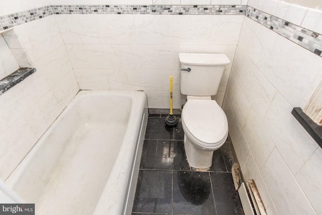 bathroom featuring a bathtub, tile patterned flooring, tile walls, and toilet