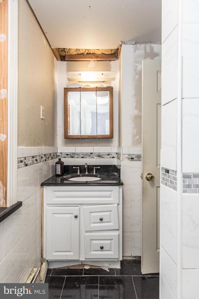 bathroom with tile patterned floors, vanity, and tile walls