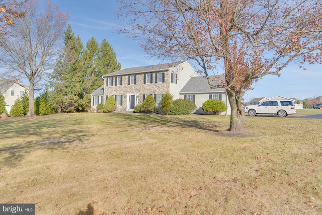 colonial-style house featuring a front lawn