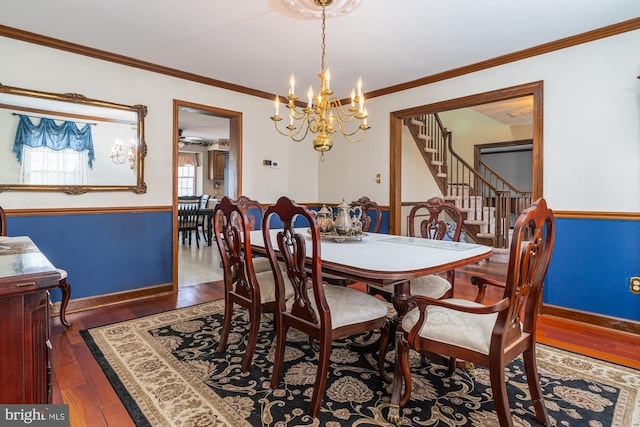 dining area with crown molding, ceiling fan with notable chandelier, and dark hardwood / wood-style floors