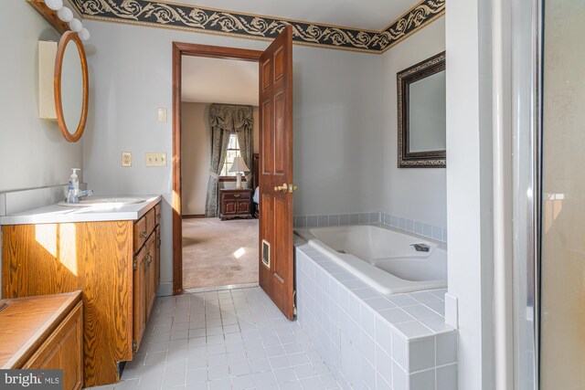 bathroom featuring vanity and a relaxing tiled tub