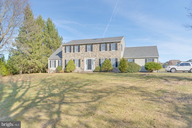 colonial-style house featuring a front lawn