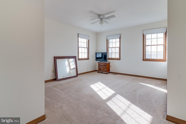 carpeted spare room featuring ceiling fan