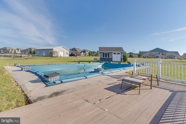 view of pool featuring an outbuilding, a yard, and a deck