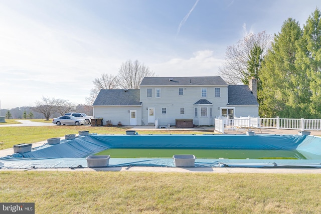 view of pool with a yard and a hot tub