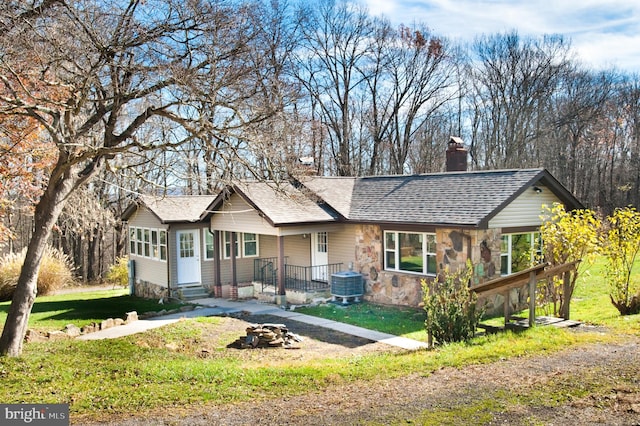 single story home featuring a front lawn and central AC unit