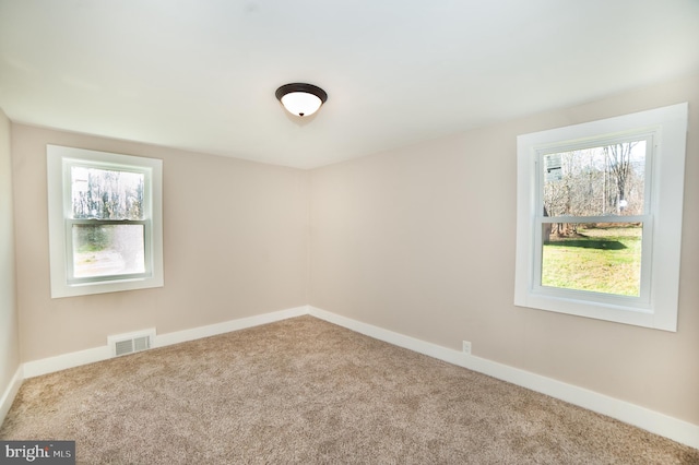 carpeted empty room featuring plenty of natural light