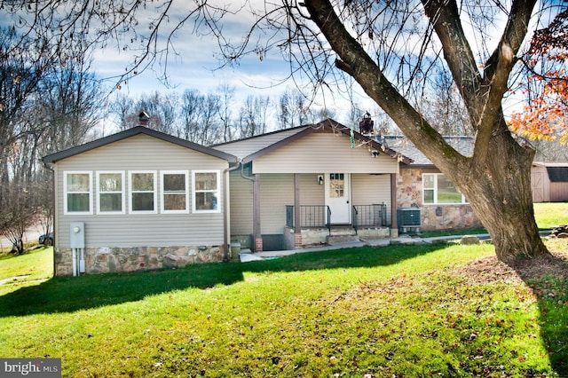 back of house featuring central AC unit and a lawn