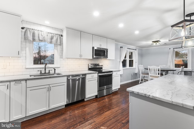 kitchen with dark hardwood / wood-style flooring, white cabinetry, sink, and appliances with stainless steel finishes