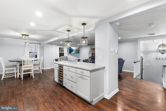 kitchen with white cabinets, decorative light fixtures, dark hardwood / wood-style flooring, and wine cooler