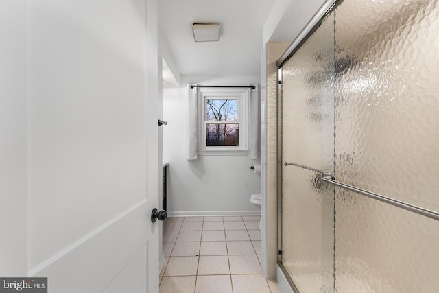 bathroom with tile patterned floors, a shower with door, and toilet