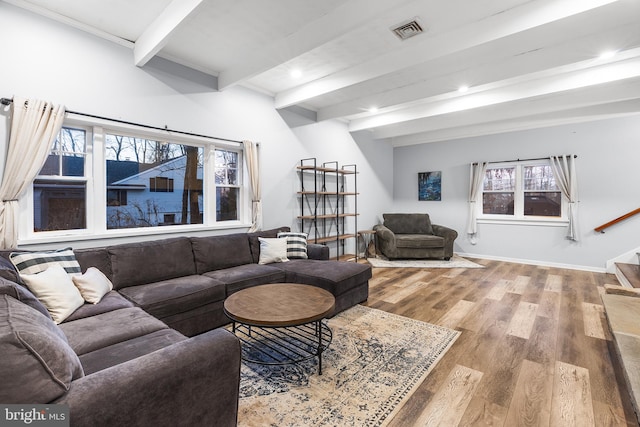 living room featuring beam ceiling and light hardwood / wood-style floors