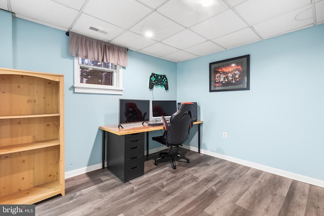 home office featuring hardwood / wood-style floors and a paneled ceiling