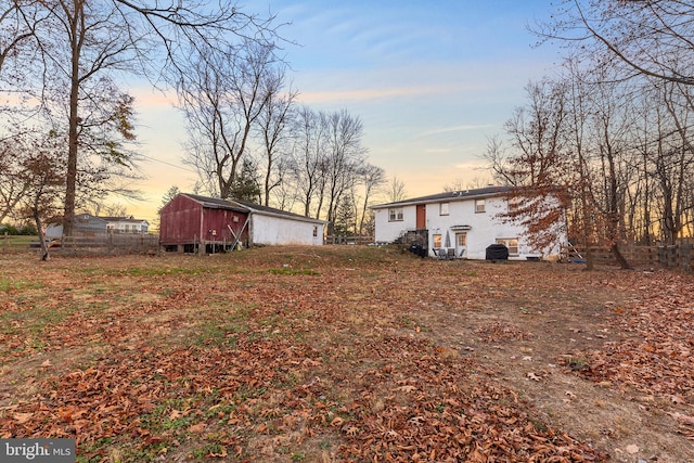 yard at dusk featuring an outdoor structure