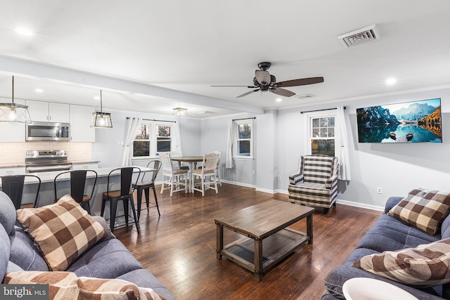 living room featuring ceiling fan and dark hardwood / wood-style floors