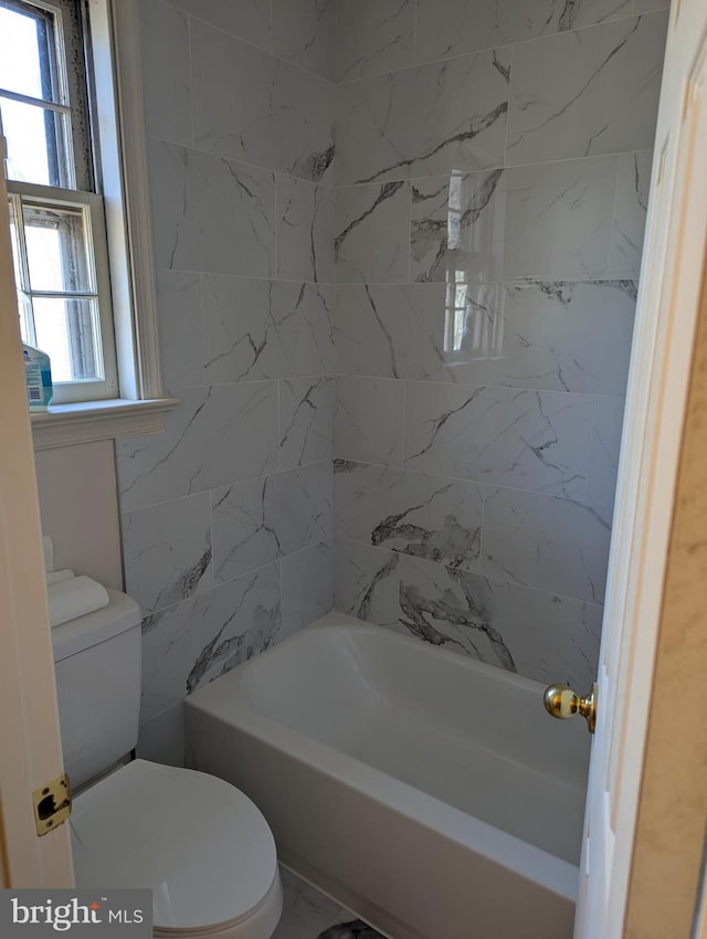 bathroom with tiled shower / bath combo and toilet