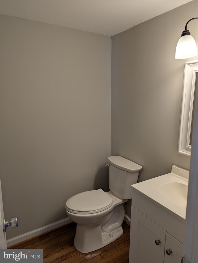 bathroom with vanity, hardwood / wood-style flooring, and toilet