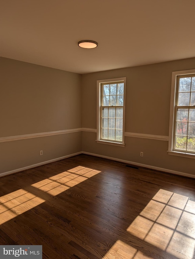 unfurnished room featuring wood-type flooring and plenty of natural light