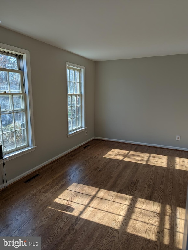 spare room with hardwood / wood-style floors and a healthy amount of sunlight