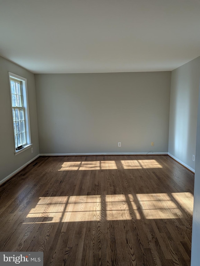 unfurnished room with dark hardwood / wood-style flooring