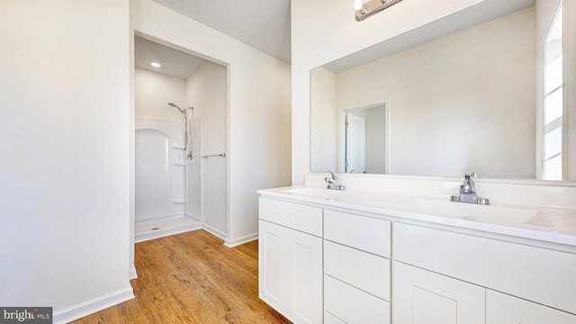 bathroom featuring hardwood / wood-style floors, vanity, and walk in shower