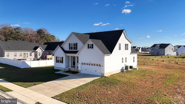 view of front of home featuring central AC, a front lawn, and a garage