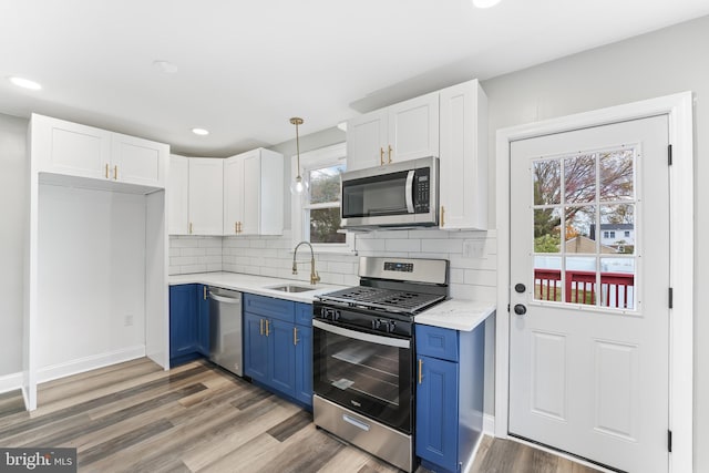 727 Clayton, New Castle, DE 19720 - kitchen featuring appliances with stainless steel finishes, blue cabinets, a sink, white cabinetry, and light wood-style floors