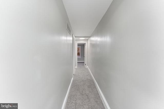 hallway featuring light colored carpet