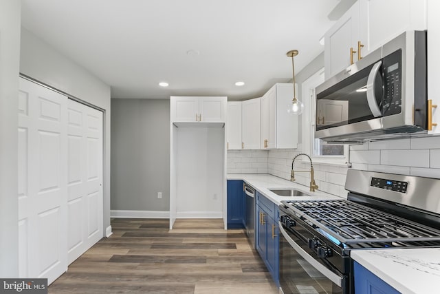 727 Clayton, New Castle, DE 19720 - kitchen with stainless steel appliances, blue cabinetry, a sink, white cabinetry, and backsplash