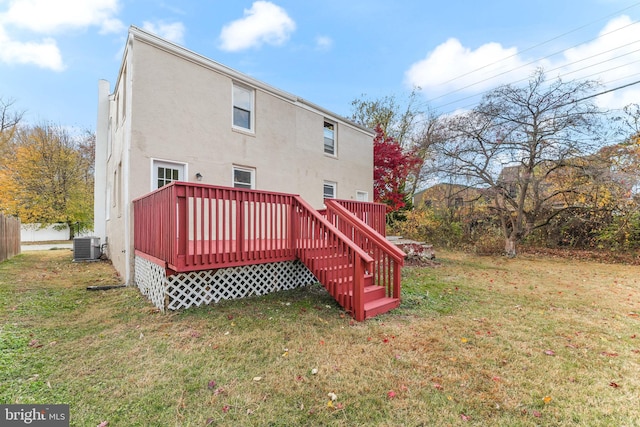 rear view of house with a lawn, central air condition unit, and a wooden deck