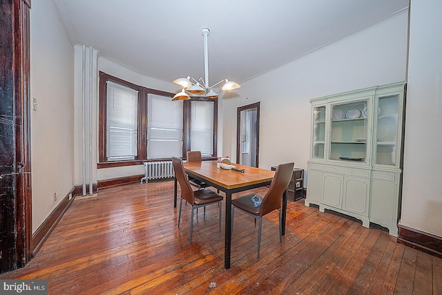 dining space featuring radiator heating unit, dark wood-type flooring, and a notable chandelier