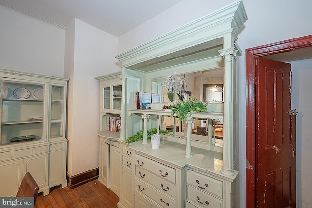 interior space with decorative columns, cream cabinets, and light hardwood / wood-style floors