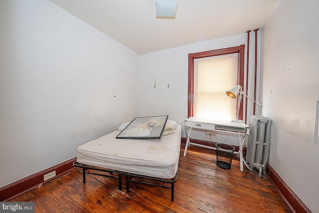 bedroom featuring dark hardwood / wood-style flooring and radiator heating unit