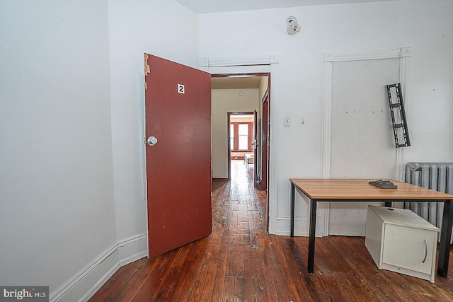 hallway with radiator heating unit and dark wood-type flooring