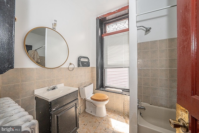 full bathroom featuring vanity, shower / bath combo with shower curtain, tile walls, tile patterned flooring, and toilet